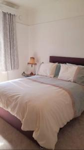 um quarto com uma grande cama branca e uma janela em Quaint little guest suite with private parking em Newport