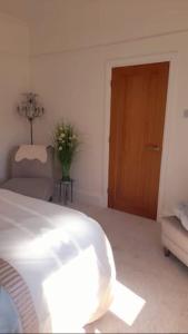 1 dormitorio con 1 cama y puerta de madera en Quaint little guest suite with private parking en Newport