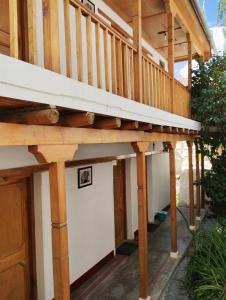 une terrasse en bois au-dessus d'un garage sous une maison dans l'établissement Gomang guest house Leh, à Leh