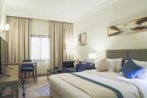 a hotel room with a bed and a desk at Safwat Alkhobar Hotel in Al Khobar