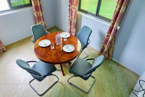 einen Holztisch und Stühle in einem Zimmer in der Unterkunft Indigo cottage and Apartment in Kumasi