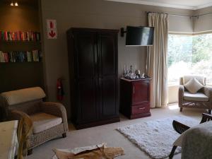 uma sala de estar com uma estante de livros e uma televisão em Perle Du Cap em Paarl