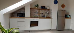 a kitchen with white cabinets and a refrigerator at DITA Osijek, centar grada in Osijek