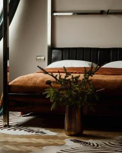 a bedroom with a bed and a vase of flowers at Hotel Monopol in Katowice