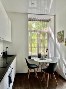a kitchen with a table and chairs and a window at Vabriku 6 Apartment with sauna in Rakvere