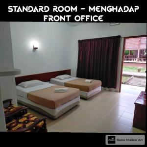 two beds in a room with a front office at Seri Indah Resort in Kuala Terengganu