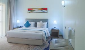 a bedroom with a large bed with blue walls at Safwat Alkhobar Hotel in Al Khobar