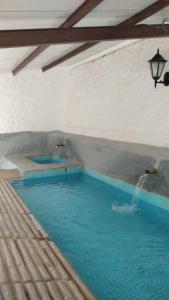 a swimming pool with two water fountains in a building at Apartamentos El Callejón in Riópar