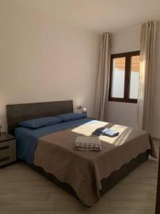ein Schlafzimmer mit einem Bett und einem Handtuch darauf in der Unterkunft LOCAZIONE TURISTICA "RI-ALE" a DUE PASSI DAL MARE BARI SARDO - OGLIASTRA - COD IUN Q8596 in Bari Sardo