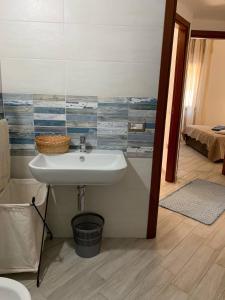 ein Badezimmer mit einem Waschbecken und ein Schlafzimmer mit einem Bett in der Unterkunft LOCAZIONE TURISTICA "RI-ALE" a DUE PASSI DAL MARE BARI SARDO - OGLIASTRA - COD IUN Q8596 in Bari Sardo