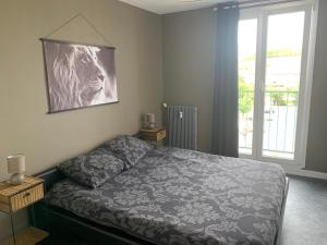 a bedroom with a bed and a large window at Appartement tout confort dans une résidence calme in Givet