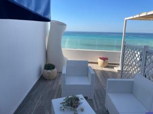 uma varanda com cadeiras e vista para o oceano em Salento Sottovento Luxury BeB em Torre Lapillo