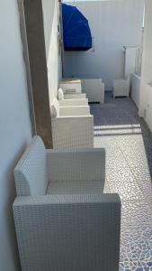 um grupo de cadeiras brancas sentadas numa sala em Salento Sottovento Luxury BeB em Torre Lapillo