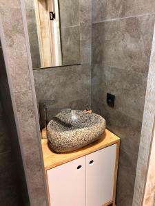 a bathroom with a stone sink and a mirror at Vavilon in Karakol