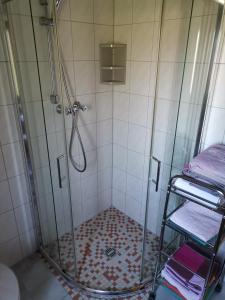 a shower with a glass shower stall with towels at Ferienhaus Happel in Bad Endbach
