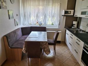 un soggiorno con tavolo e divano e una cucina di Ferienhaus Happel a Bad Endbach