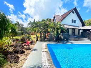 a house with a swimming pool in front of a house at Villa Ayapana in Le Morne