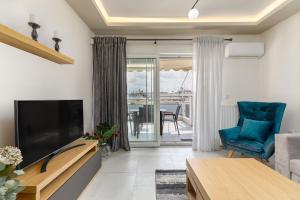 sala de estar con TV de pantalla plana y silla azul en Central Luxury Apartment, en Tesalónica