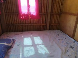 RAMMANG-RAMMANG HOUSE في Maros: غرفة صغيرة مع سرير مع نافذة