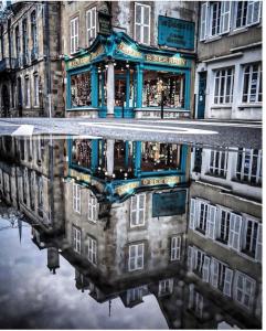 un reflet d'un bâtiment dans une flaque dans l'établissement Beau studio centre ville, à Moulins