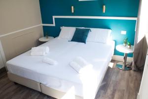 a bedroom with a white bed with a blue wall at Le Petit Bijou in Rome