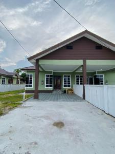 a house with a white fence in front of it at De Jara Guesthouse, Kuala Dungun in Dungun