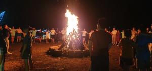 a crowd of people standing around a large bonfire at For You Homestay in Ninh Binh