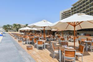 an outdoor dining area with tables and umbrellas at Kempinski Hotel Aqaba in Aqaba