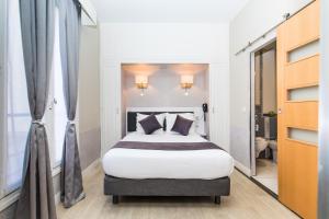 sypialnia z dużym łóżkiem w pokoju w obiekcie HOTEL DE PARIS MONTPARNASSE w Paryżu