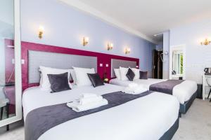 two beds in a hotel room with white and purple at HOTEL DE PARIS MONTPARNASSE in Paris +277 photos