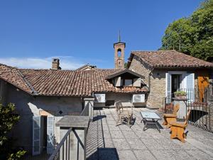 a patio with chairs and a table and a building at Casa Cecilia in Santo Stefano Belbo