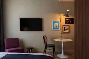 ein Schlafzimmer mit einem Bett, einem Tisch und einem Stuhl in der Unterkunft Bona Fide Main Square Designer Apartments in Zagreb