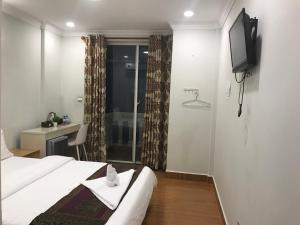 a hotel room with a bed and a television at LK Apartment & Hotel in Sihanoukville