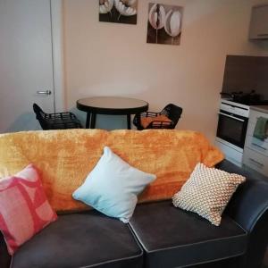 a couch with pillows on it in a living room at Carvetii - Norman House - 2nd floor, 1 bedroom flat in Boʼness