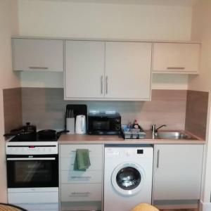 a kitchen with a washing machine and a sink at Carvetii - Norman House - 2nd floor, 1 bedroom flat in Boʼness