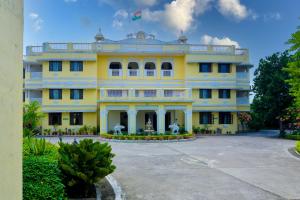 Saipur的住宿－Singrauli Palace Heritage Hotel，上面有旗帜的黄色建筑