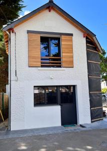 a white building with a window and a garage at Le cache a l eau in Le Pouliguen