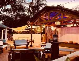eine Terrasse mit einem Pavillon mit Stühlen und einem Tisch in der Unterkunft CHEZ ALAIN in Toliara