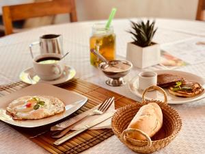 einen Tisch mit Teller mit Lebensmitteln und einen Korb mit Brot in der Unterkunft CHEZ ALAIN in Toliara