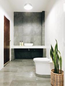 a bathroom with a toilet and a sink and a plant at Pak Ping Ing Jai in Ban Mai