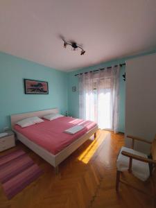 a bedroom with a large bed and a window at Apartment Maskarin Rab in Mundanije
