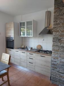 a kitchen with white cabinets and a stove at Apartment Maskarin Rab in Mundanije