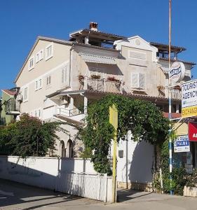 een groot wit huis met een wit hek bij Porto del Mar Medulin B & B in Medulin