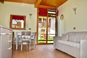 a living room with a couch and a table and chairs at Appartamento 1 Baita Sosio Livigno in Livigno