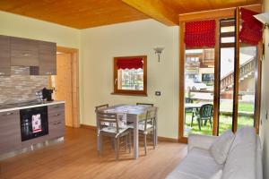a kitchen and living room with a table and chairs at Appartamento 1 Baita Sosio Livigno in Livigno