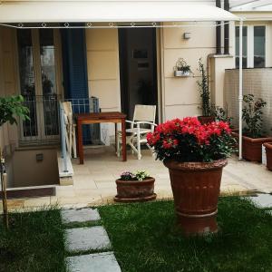 eine Terrasse mit zwei Topfpflanzen und einem Tisch in der Unterkunft CB House Tuscany 2 in Pietrasanta