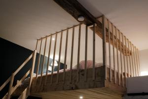 a wooden staircase with a bed in a room at Le Studio Émeraude - Topdestination-Spa in Spa