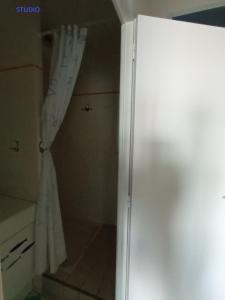 ヴィムルーにあるRésidence La Naturelleのバスルーム(シャワー、カーテン、冷蔵庫付)が備わります。