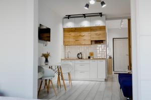 a kitchen with white cabinets and a table and chairs at ADT apartments in Almaty