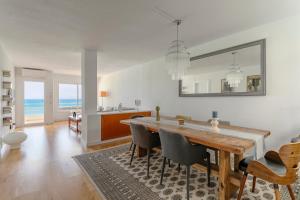Un comedor con mesa y sillas y el océano. en Lovely Beachfront Apartment with Panoramic Views, en Altea